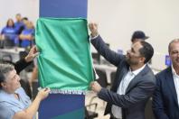 homem e mulher removendo o pano da placa de inauguração da casa do trabalhador